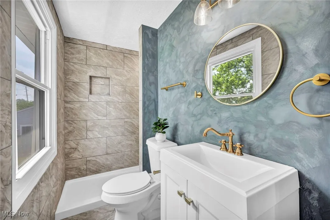 Bathroom featuring vanity and tiled shower