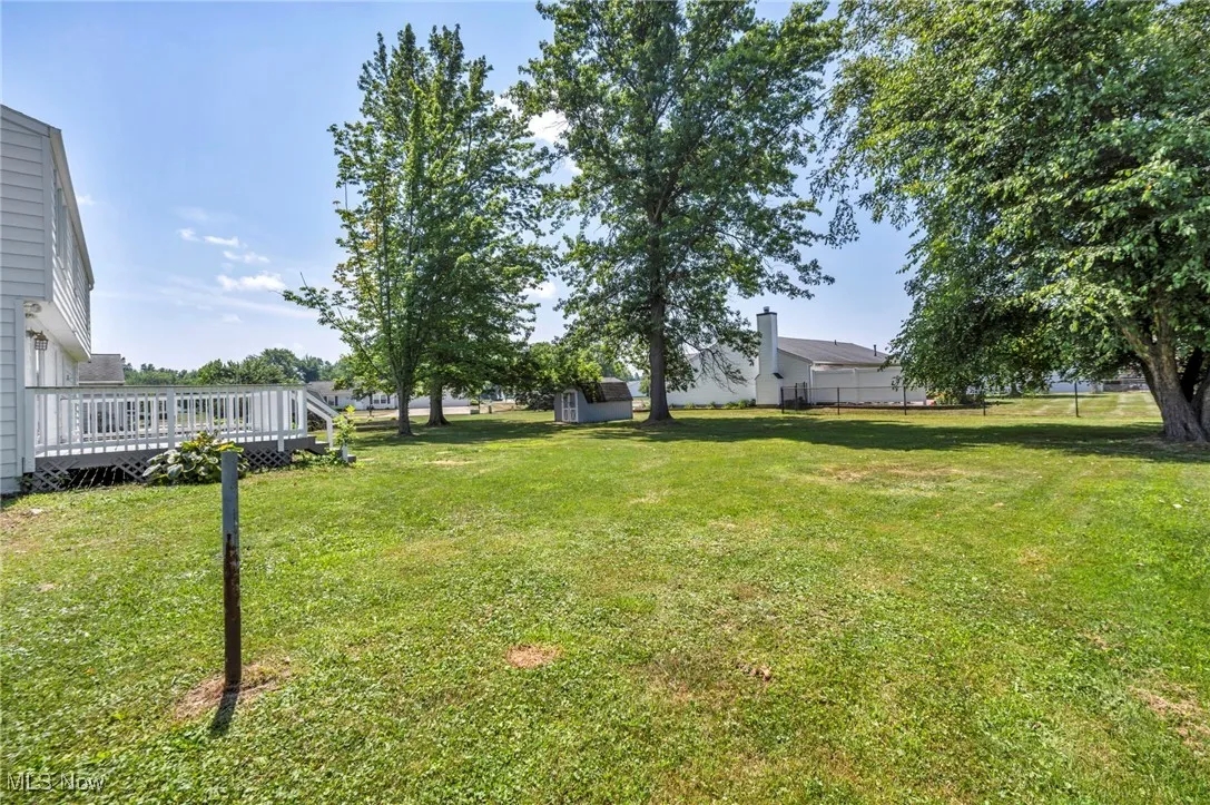 View of grassy yard featuring a wooden deck