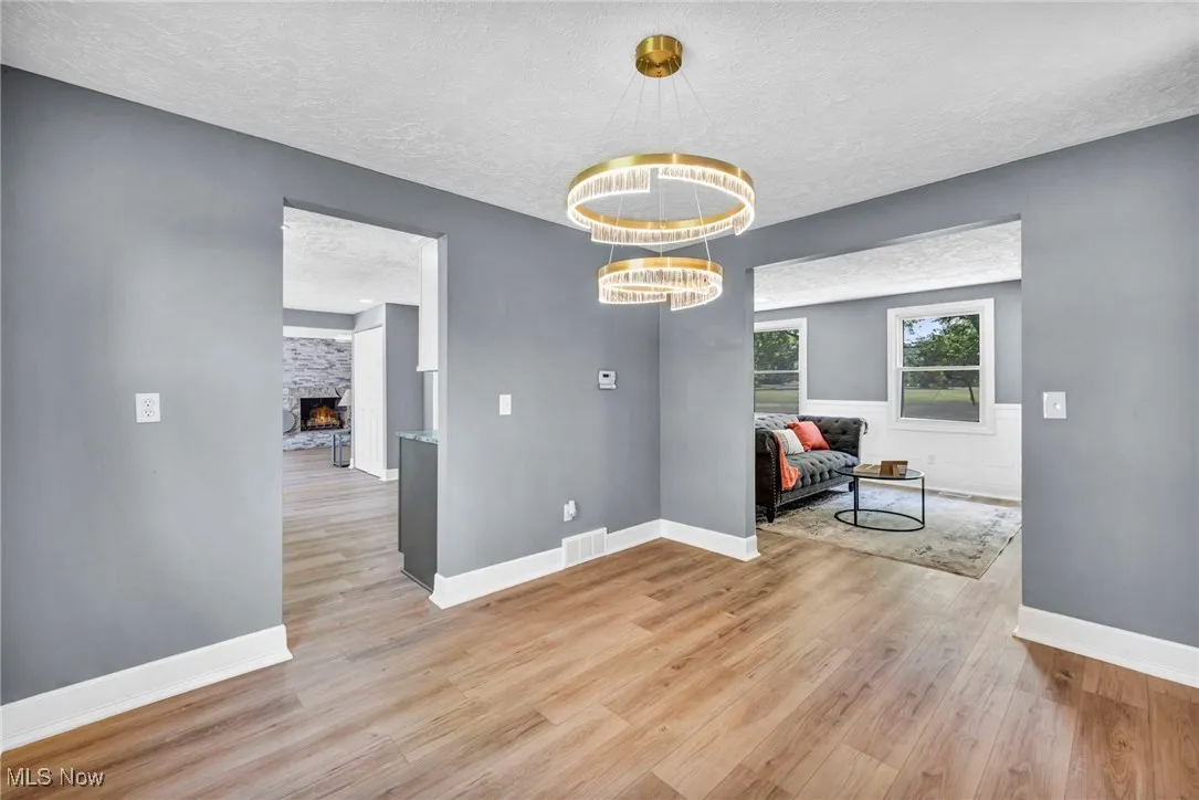 Unfurnished dining area with a textured ceiling, wood finished floors, and a fireplace