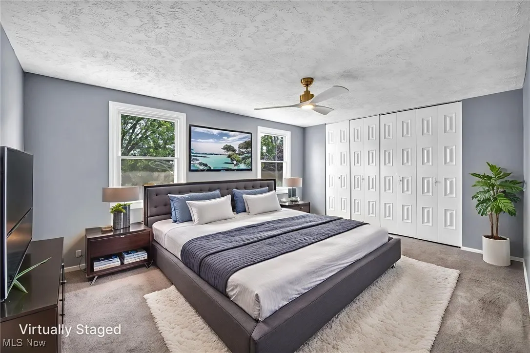 Bedroom with carpet floors, a closet, ceiling fan, and a textured ceiling