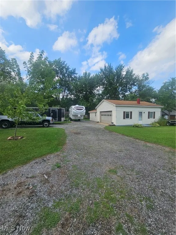 View of front of house featuring driveway and a front lawn