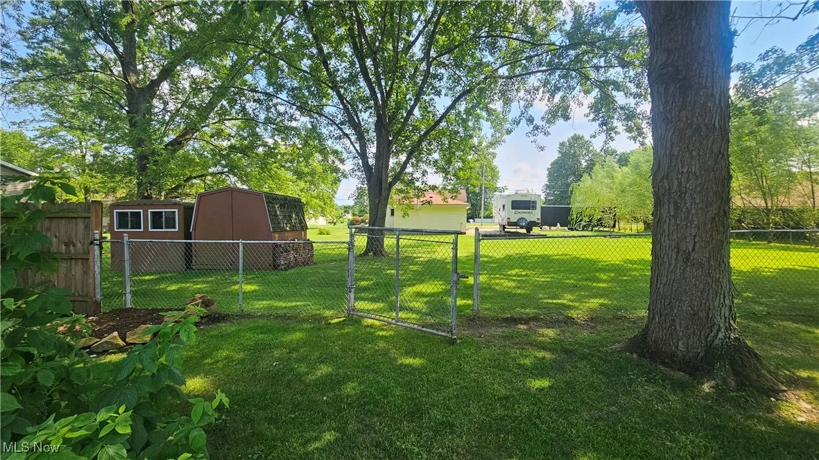 Fenced backyard with a storage shed and a gate