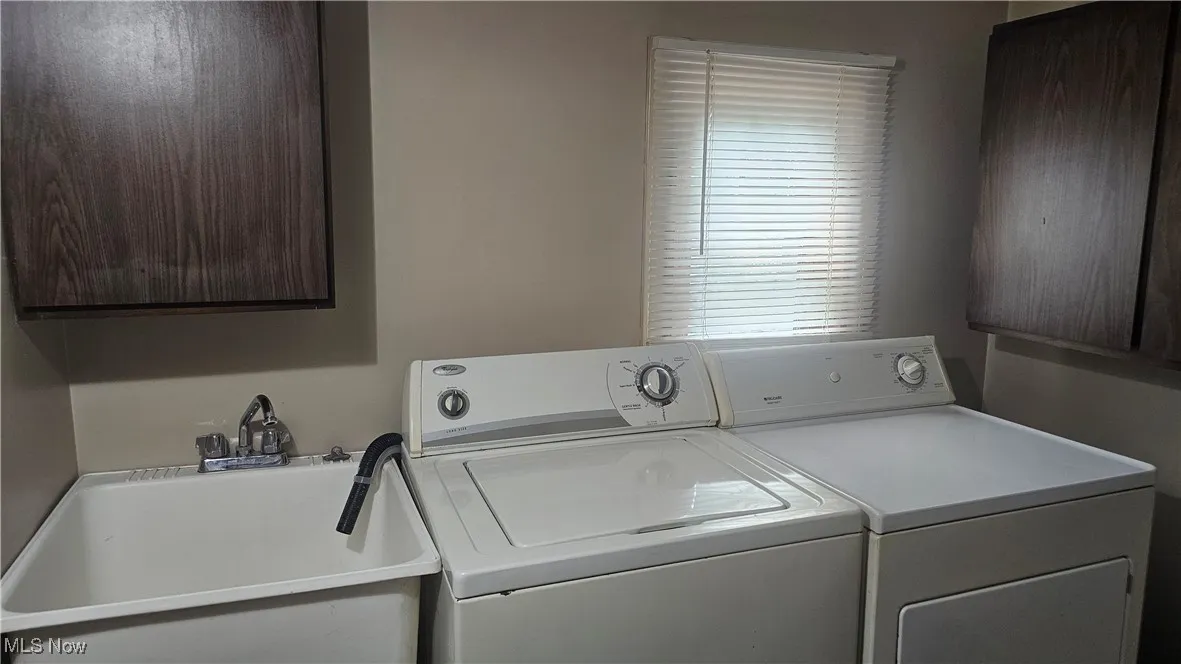 Laundry room with separate washer and dryer and cabinet space