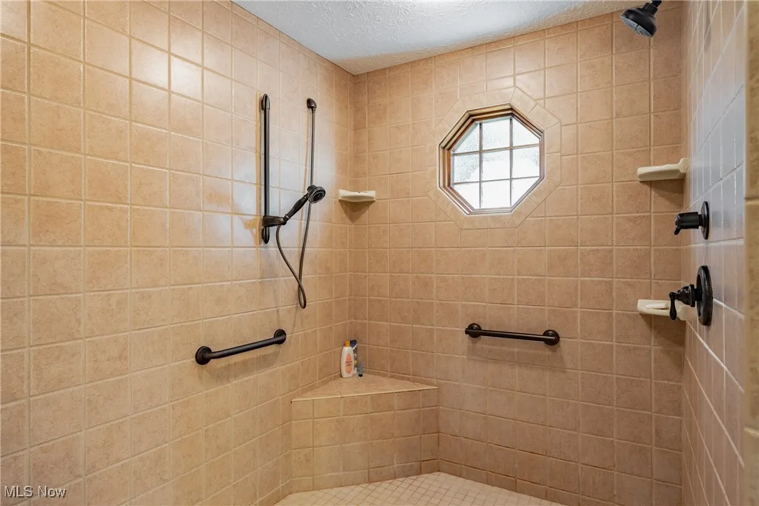 Huge walk-in shower offers 3 shower heads and built-in seating
