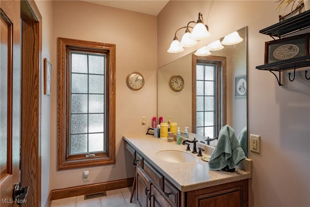 Main bath offers Solid surface counters, ceramic floors, with the shower and toilet located off to the left