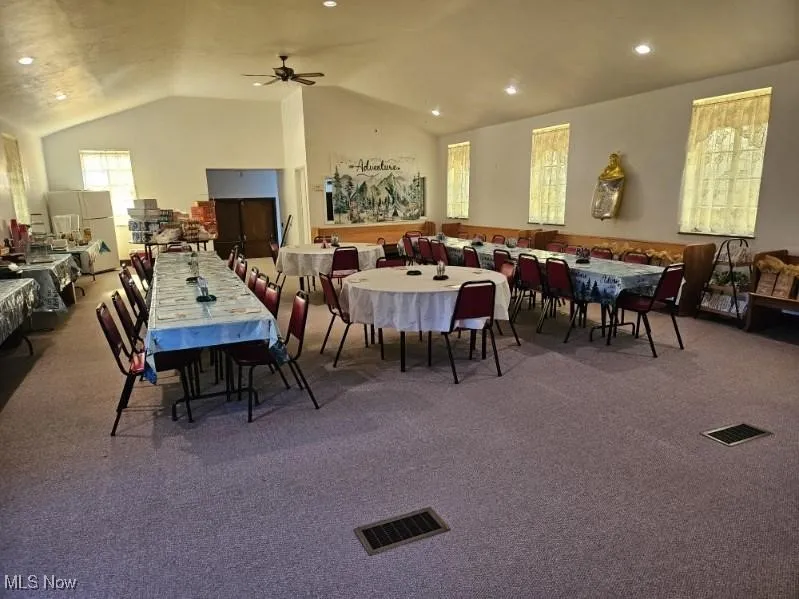 Dining area with carpet floors, lofted ceiling, a ceiling fan, and recessed lighting