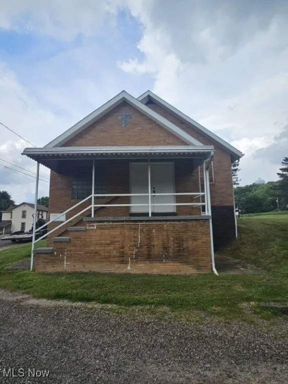 Bungalow featuring brick siding
