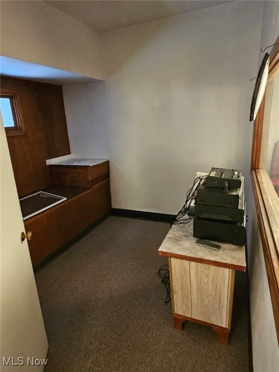 Kitchen with dark colored carpet and light countertops