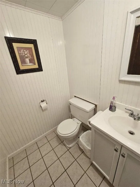 Bathroom featuring vanity, tile patterned floors, and wood walls