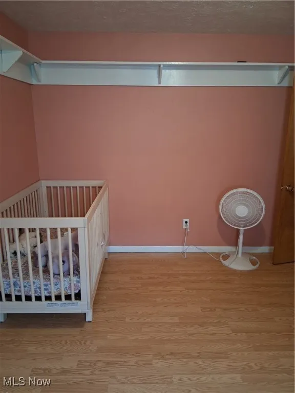 Unfurnished bedroom with wood finished floors and baseboards