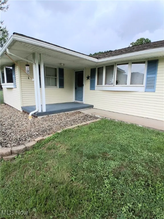 View of front of property featuring a porch and a front lawn