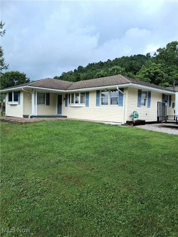 Single story home featuring a front lawn and covered porch