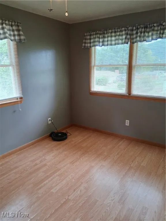 Spare room featuring wood finished floors and baseboards