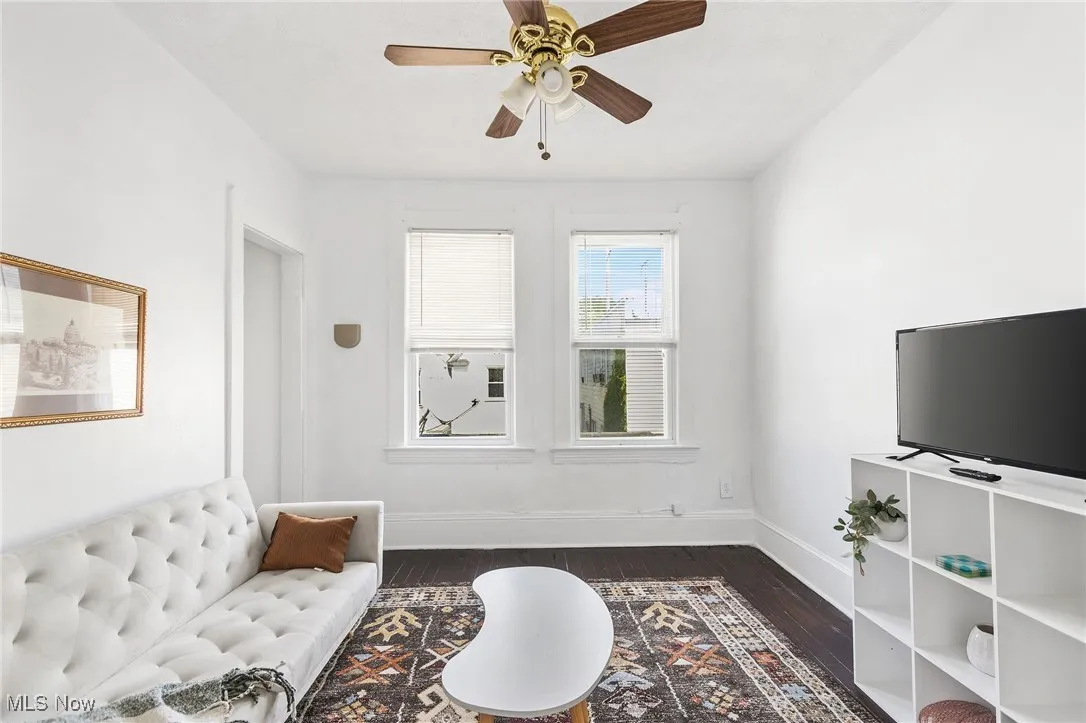 Living area featuring dark wood finished floors and ceiling fan
