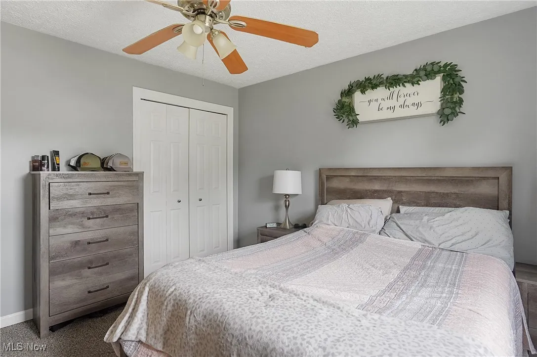 Bedroom featuring a closet, a ceiling fan, and a textured ceiling