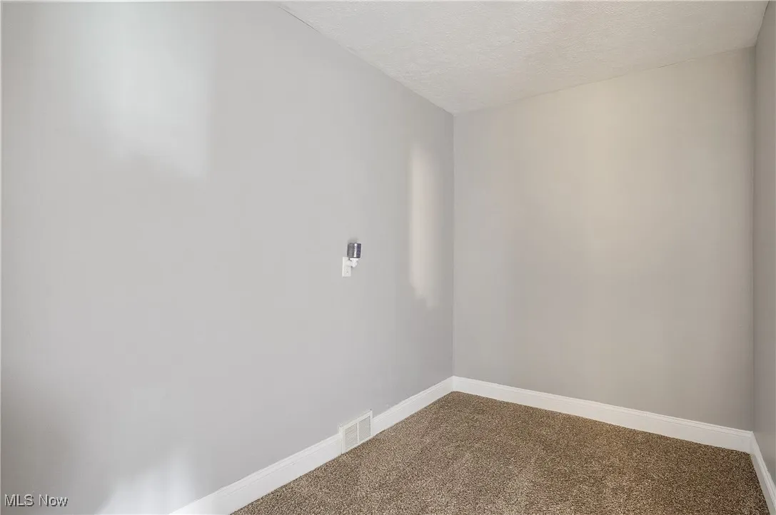 Spare room with carpet flooring and a textured ceiling