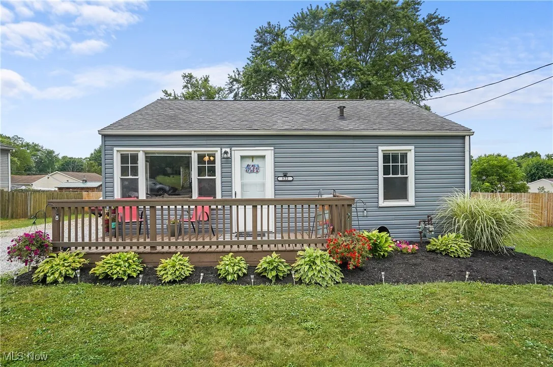 Back of property featuring a deck and roof with shingles