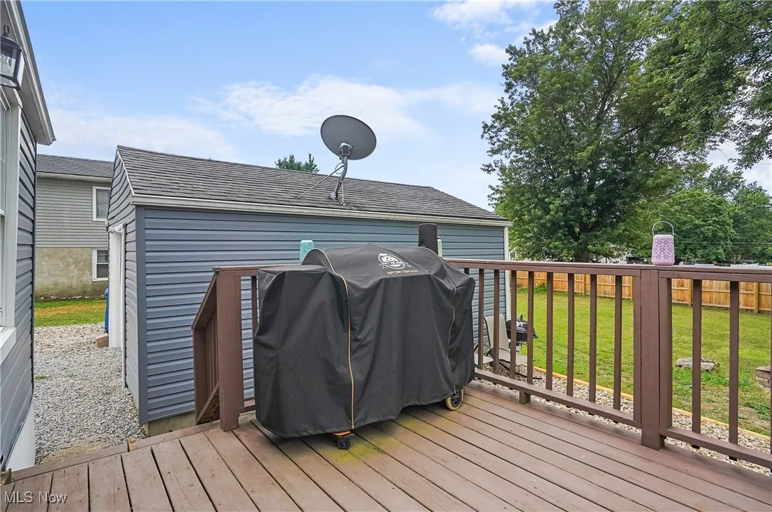 Wooden deck featuring grilling area and a yard