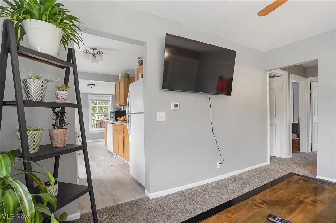 Unfurnished living room with light carpet and a ceiling fan