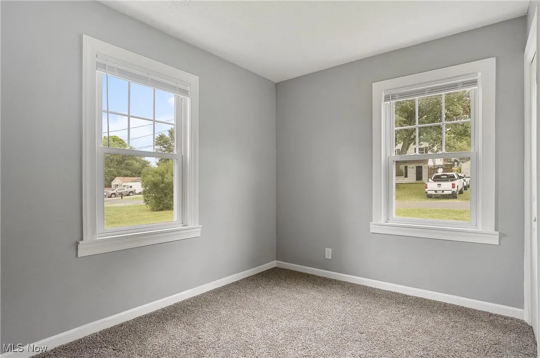 Carpeted spare room with baseboards