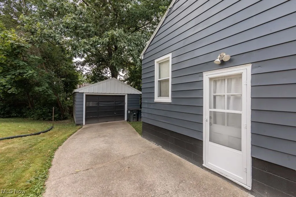 Detached garage featuring concrete driveway