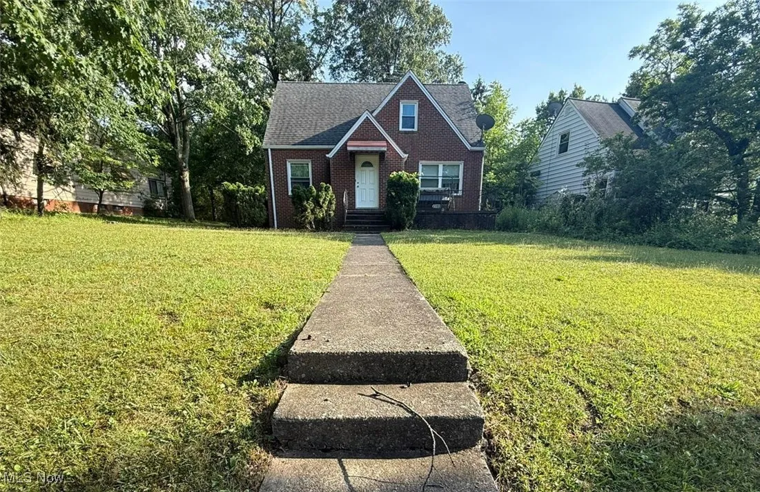 View of front of property featuring a front yard and brick siding