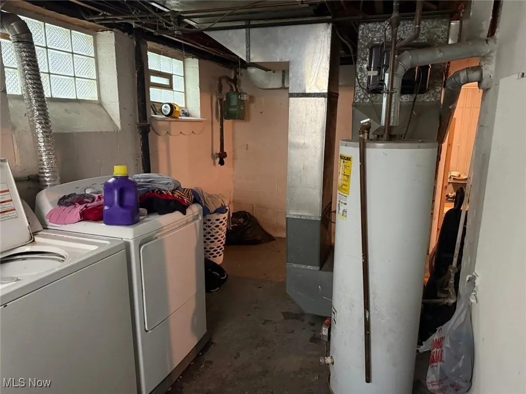 Laundry area with separate washer and dryer and gas water heater