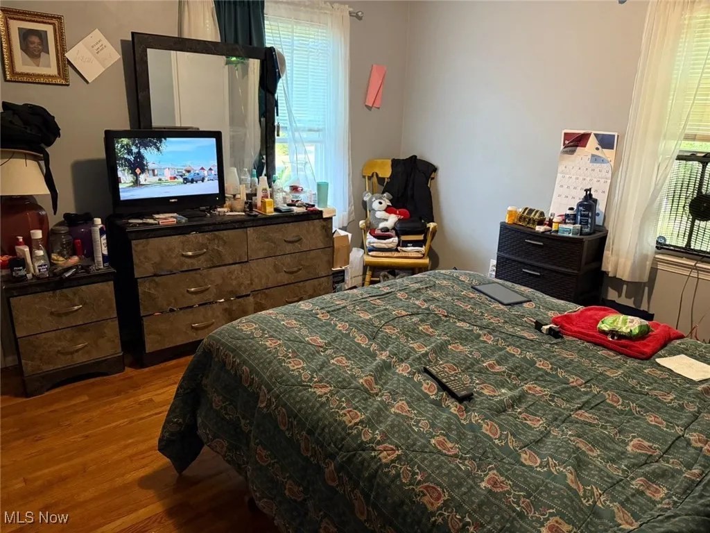 Bedroom featuring wood finished floors and multiple windows