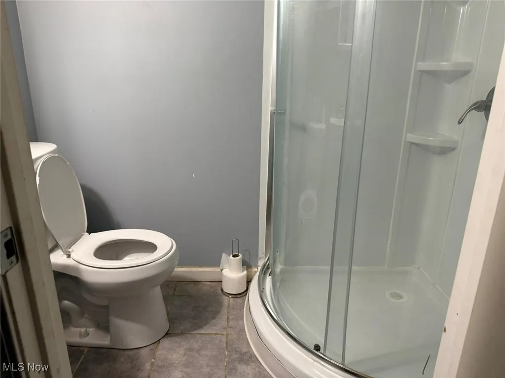Bathroom with a stall shower and tile patterned floors
