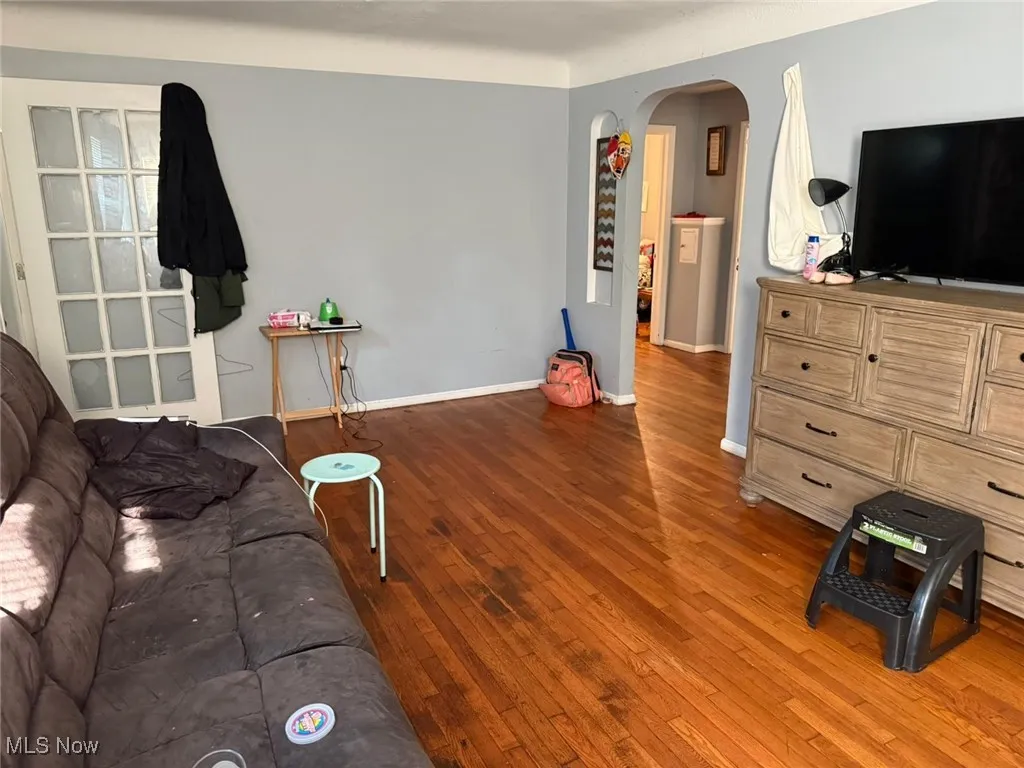 Living room featuring arched walkways and hardwood / wood-style flooring