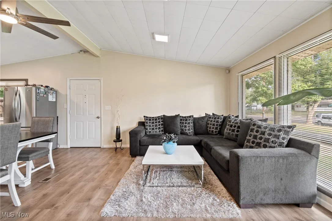 Living room with light wood-style flooring and ceiling fan
