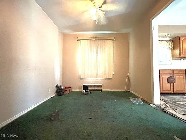 Spare room featuring carpet and ceiling fan
