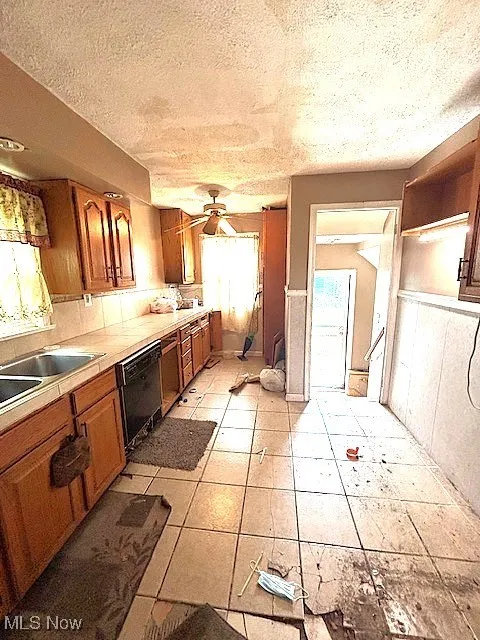 Kitchen featuring brown cabinets, a textured ceiling, ceiling fan, open shelves, and dishwasher