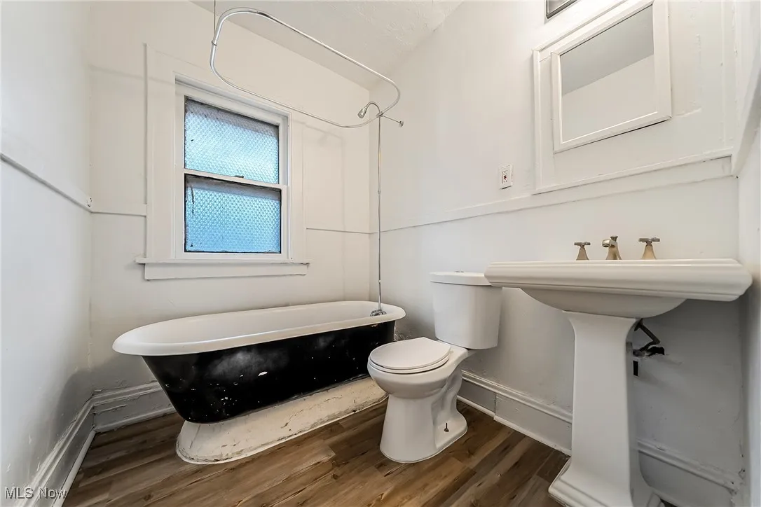 Bathroom with a soaking tub and wood finished floors