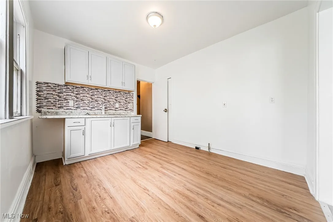 Kitchen featuring light wood-type flooring and decorative backsplash