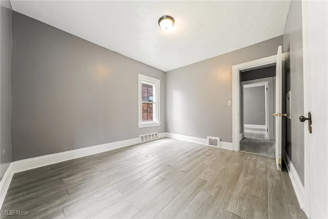 Spare room featuring light wood-style floors and baseboards