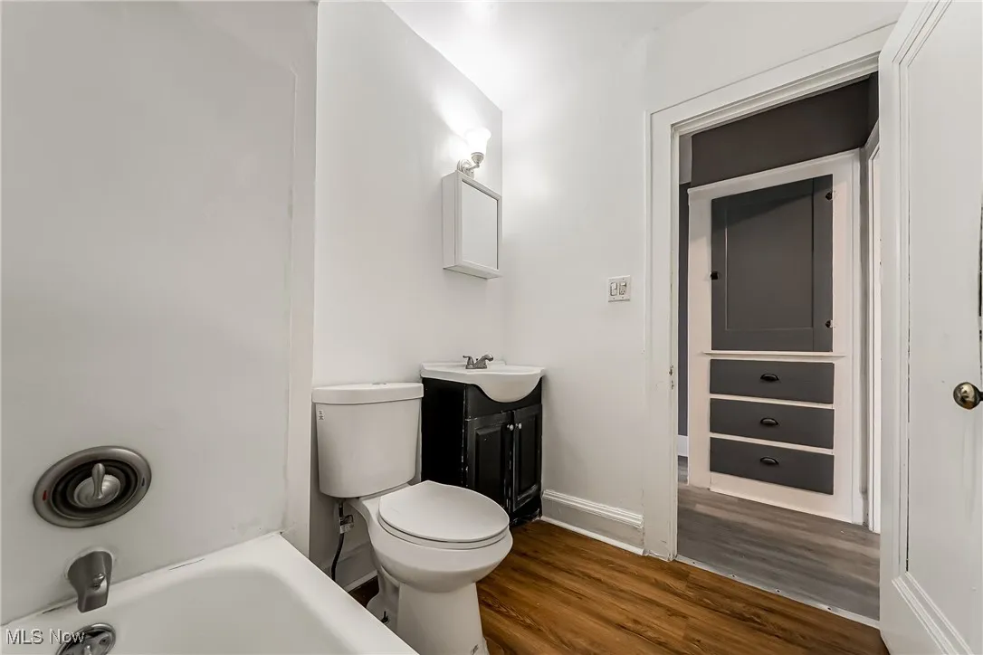 Bathroom with wood finished floors, vanity, and a tub