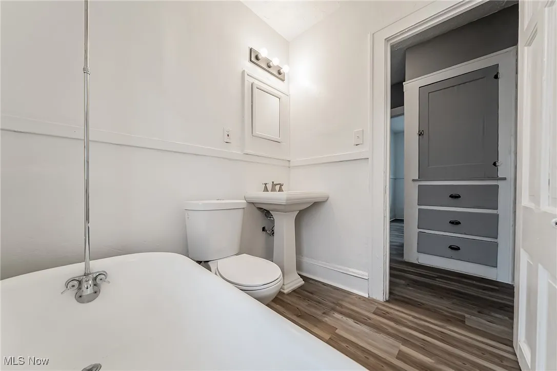 Bathroom featuring a freestanding bath and wood finished floors