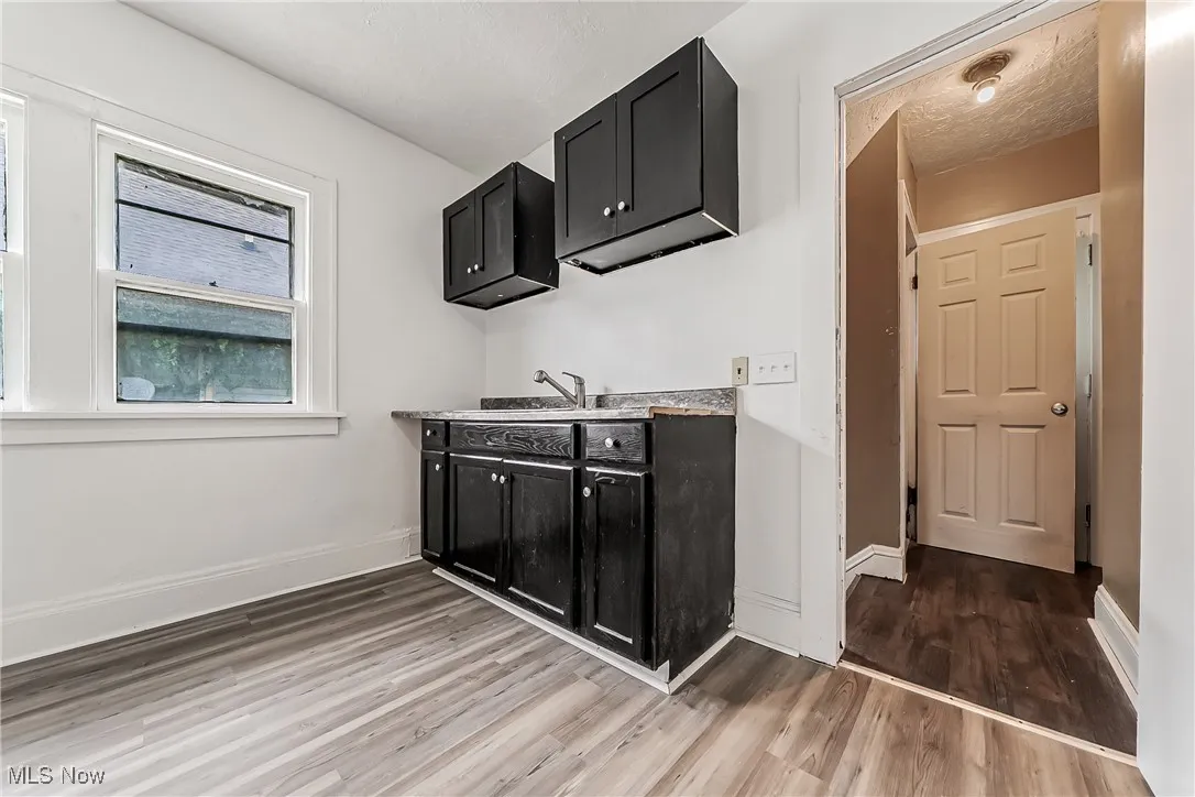 Laundry area featuring light wood finished floors and baseboards