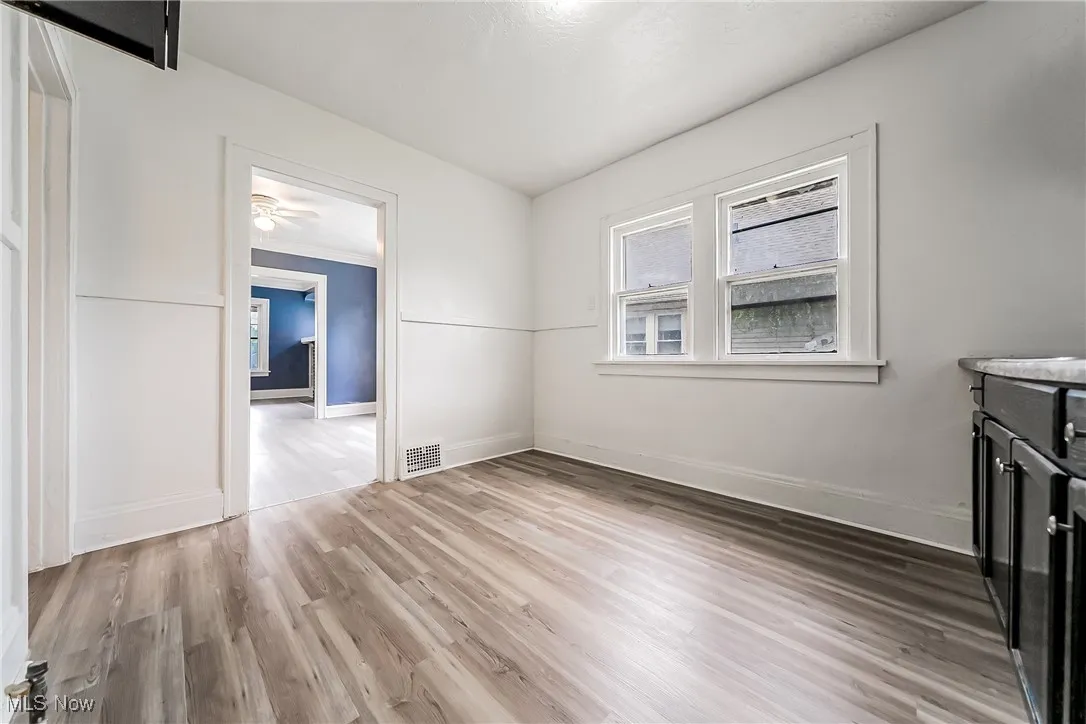 Unfurnished dining area featuring light wood-type flooring and baseboards