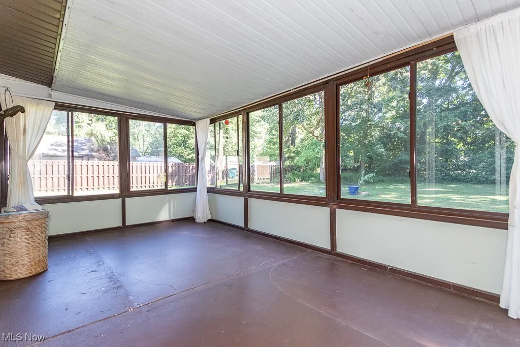 Unfurnished sunroom with concrete floors