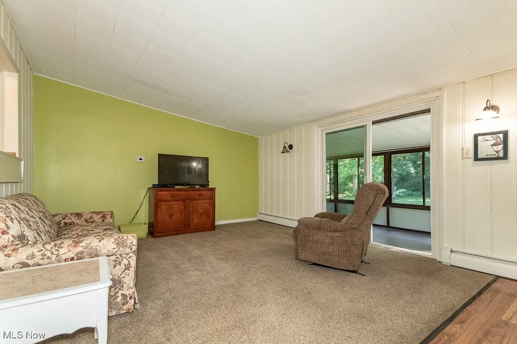 Living room featuring baseboard heating and wood finished floors