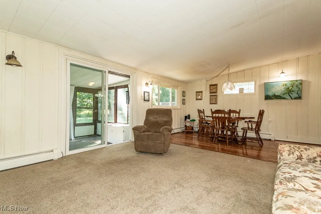 Living room featuring carpet floors and a decorative wall