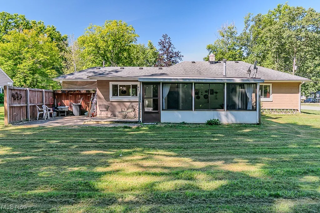 Back of house with a patio area and a sunroom