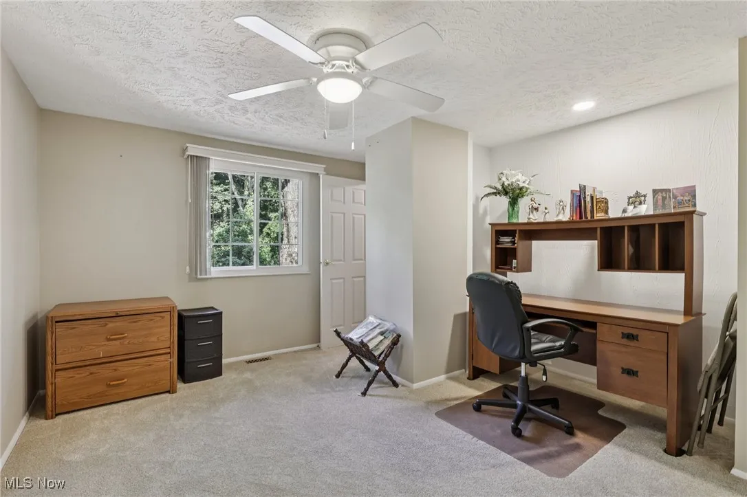 second bedroom with walk in closet and desk or sitting area