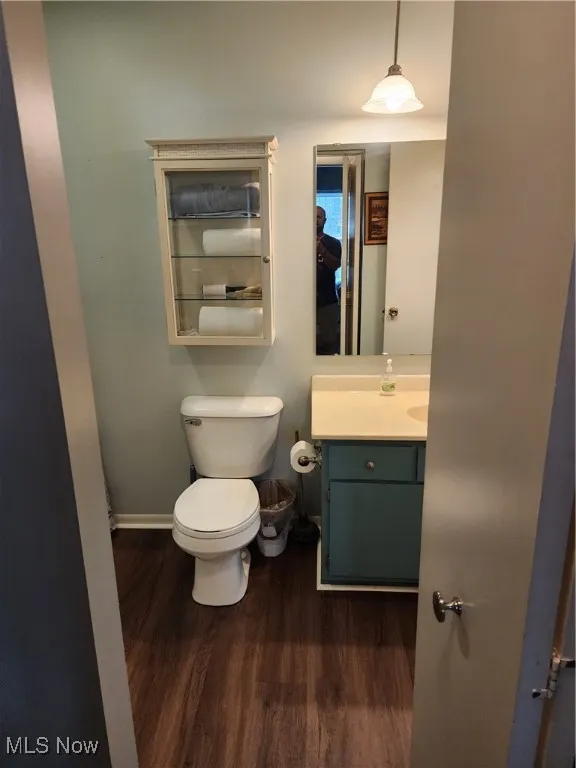 Half bath with wood finished floors and vanity