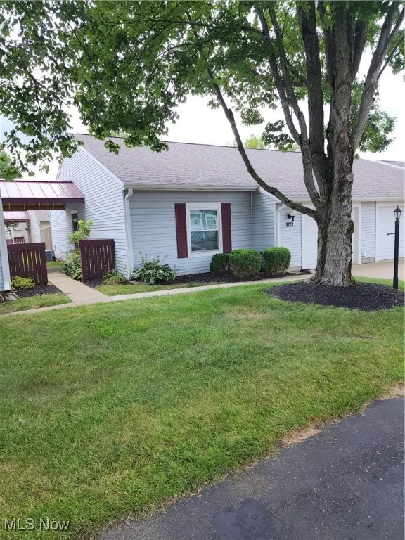 Single story home with a front lawn and roof with shingles