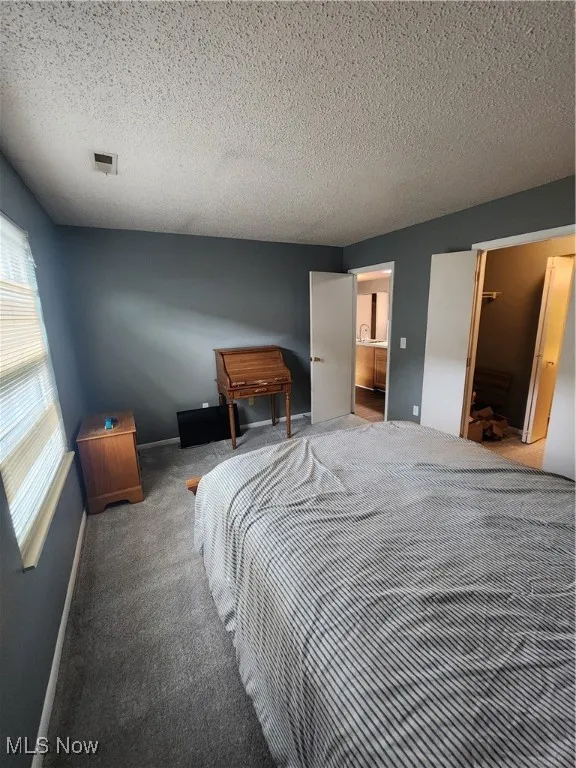 Carpeted bedroom with a textured ceiling
