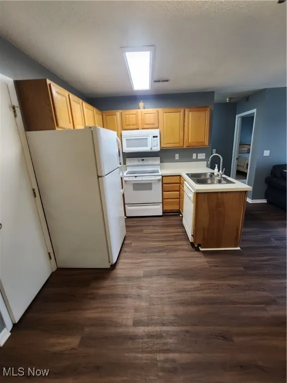 Kitchen with a peninsula, fridge, white electric stove, and dark wood-type flooring