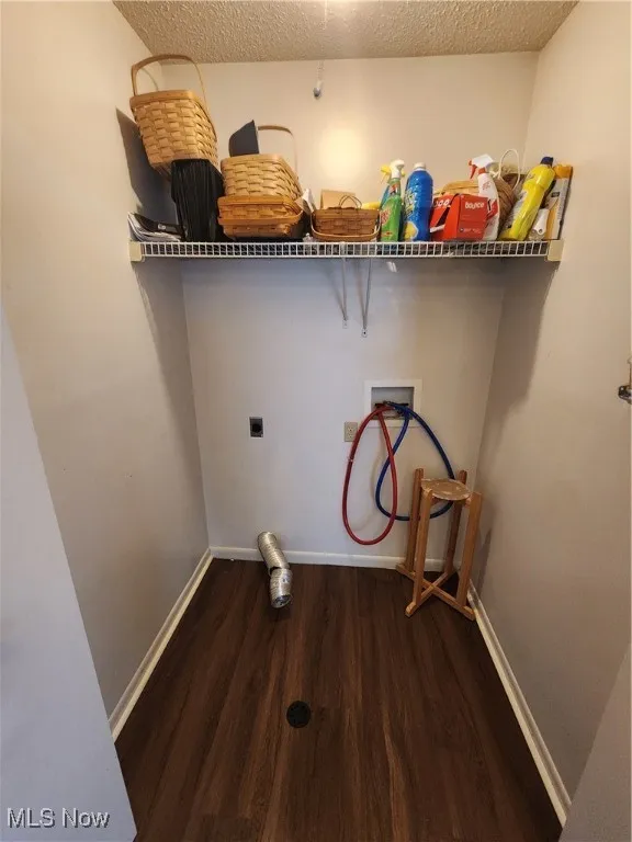 Laundry room with hookup for a washing machine, wood finished floors, a textured ceiling, and electric dryer hookup